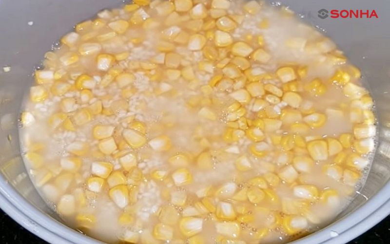 Cách nấu xôi bắp bằng nồi cơm điện. Trong quá trình nấu, bạn cần đảm bảo lượng nước vừa ngập mặt nguyên liệu